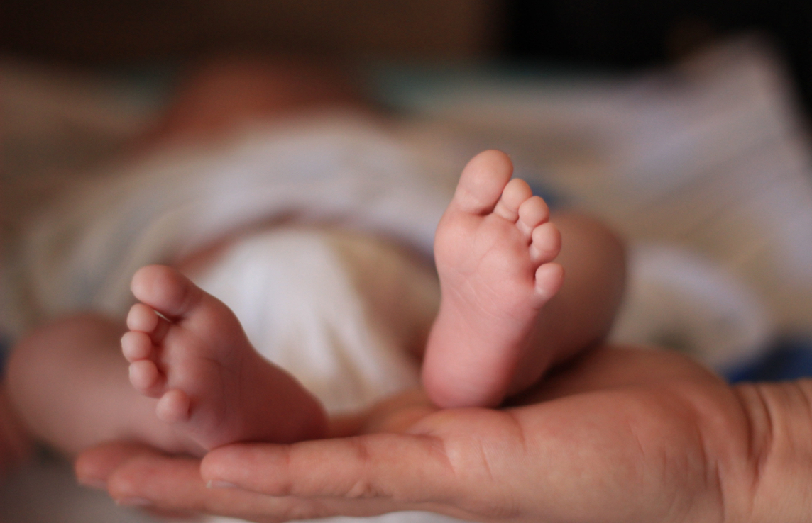 Madre sosteniendo pies de bebe