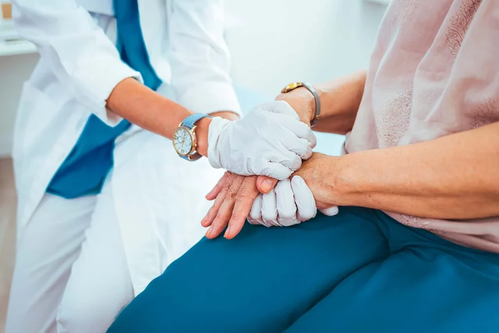 Manos de paciente siendo tomadas por su médico mientras le explica el tratamiento para el lupus