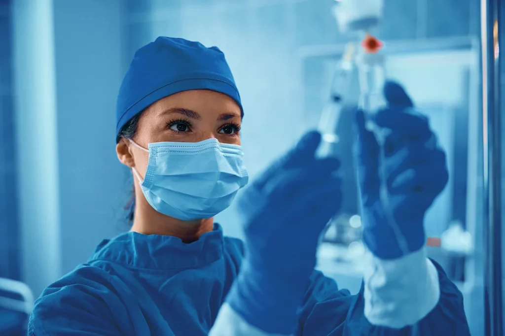 Especialista en neuroanestesia administrando medicamento para controlar al paciente durante su procedimiento quirúrgico.