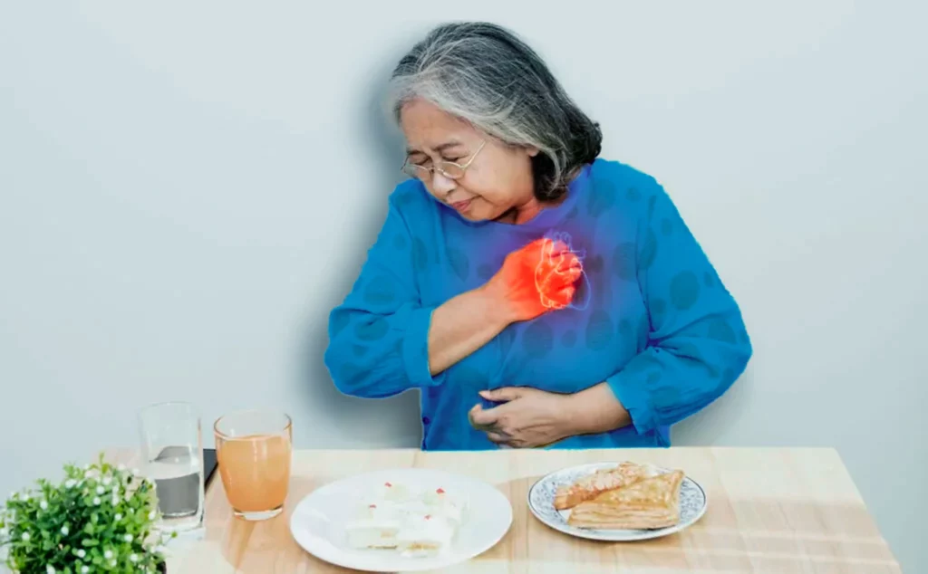 Mujer mayor apretándose el pecho y abdomen debido a que está sintiendo los síntomas de un pre infarto silencioso.