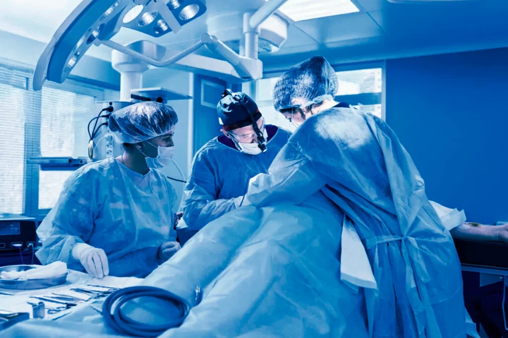 Un cirujano vascular o cardiovascular se encuentra realizando un procedimiento en un quirófano.