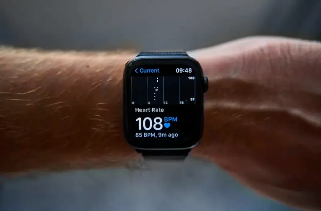 Reloj inteligente en el brazo de un hombre, indicando la medición de la frecuencia cardíaca.

