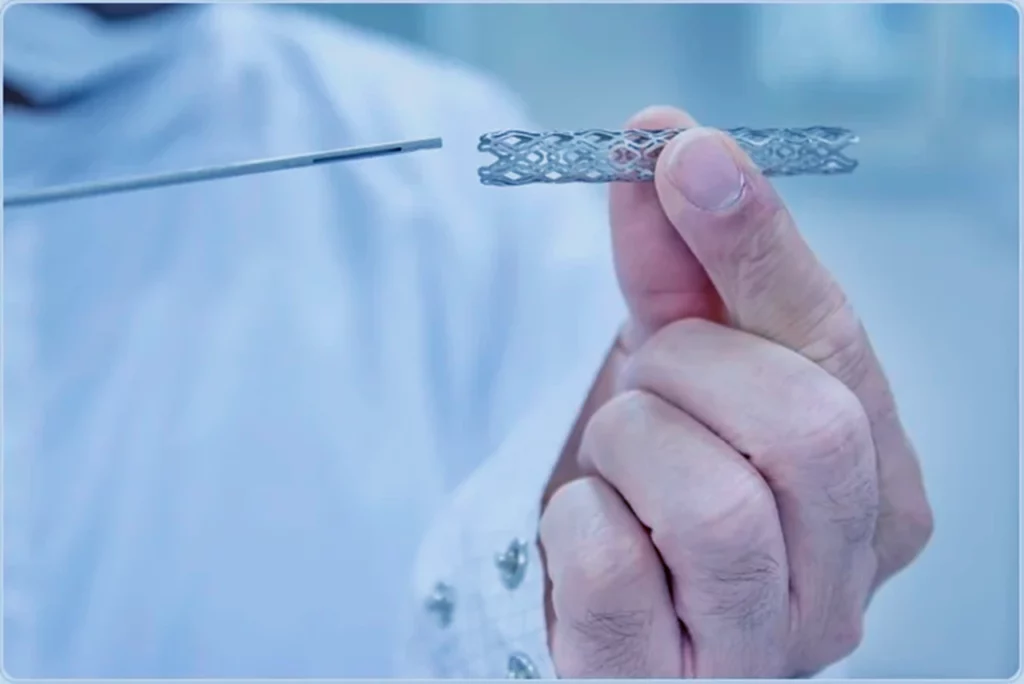 Manos de un médico sosteniendo los componentes de un stent coronario.
