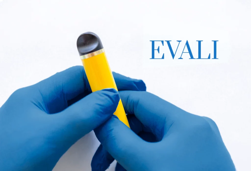 Manos con guantes quirúrgicos sosteniendo un vapeador con la palabra EVALI a un lado.