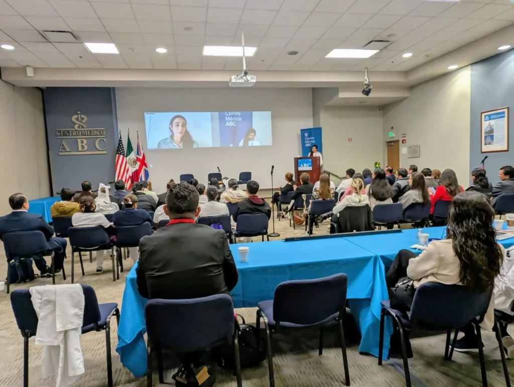 Participantes del 2o simposio internacional de cáncer de mama 2025 sentados mientras prestan atención a una charla.