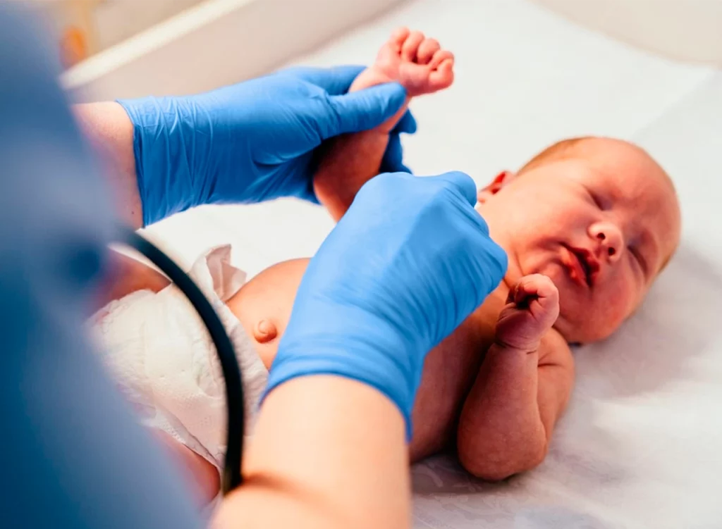 Médico revisando a un recién nacido para comprobar la evolución de la sepsis neonatal que había presentado.